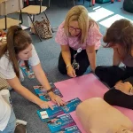 Learners arranging CPR instruction cards in order as part of a first aid training session.
