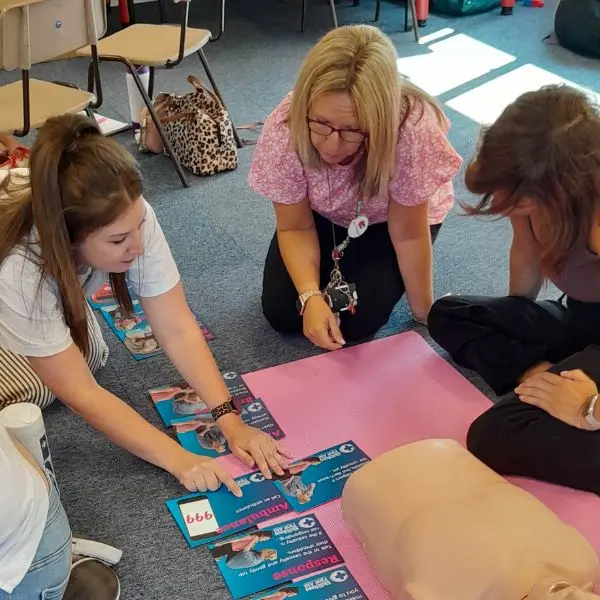 Learners arranging CPR instruction cards in order as part of a first aid training session.