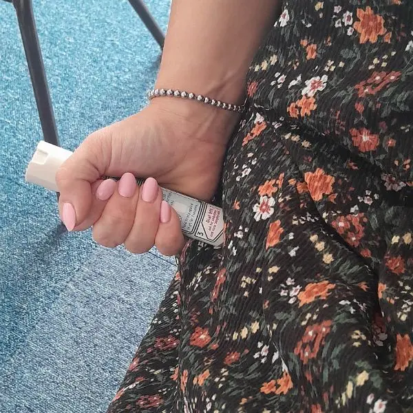 Demonstration of correct hand placement for holding and administering an auto-injector.