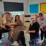 Participants seated in a training room practising first aid skills together as part of a group activity.