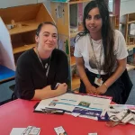 Participants discussing first aid scenarios using training booklets and worksheets.