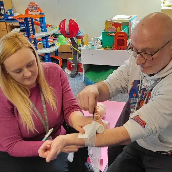 Applying a tourniquet as part of first-aid practice.